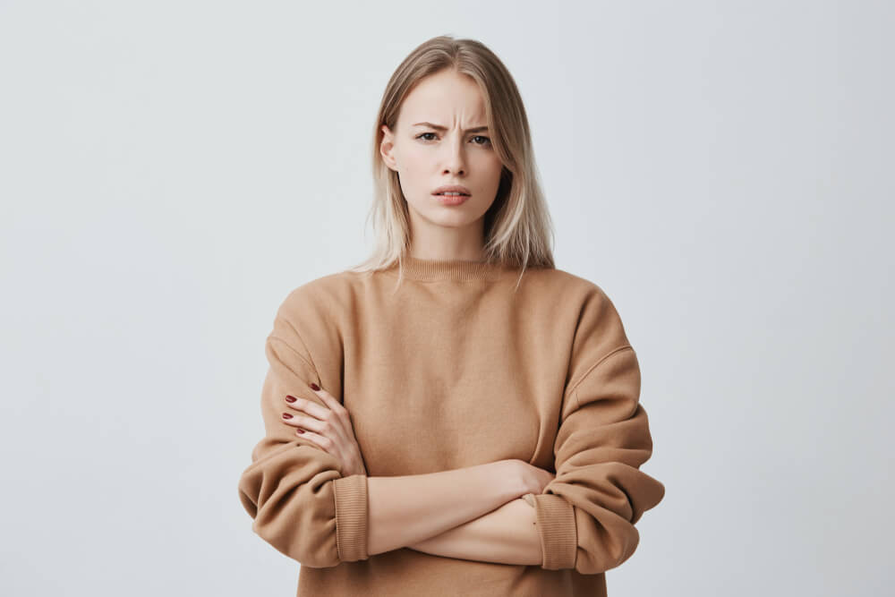 不満げに腕組みをし、仁王立ちする外国人女性