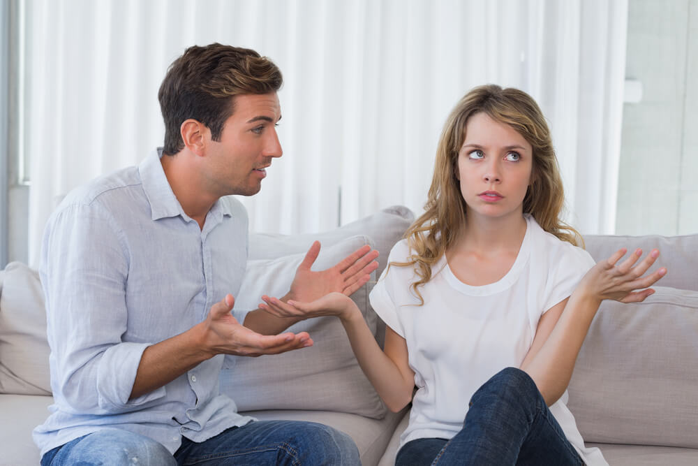 ソファに座り口論する夫婦