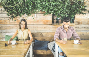 仮面夫婦を表した写真。お互いに興味がなく、スマホをいじっている