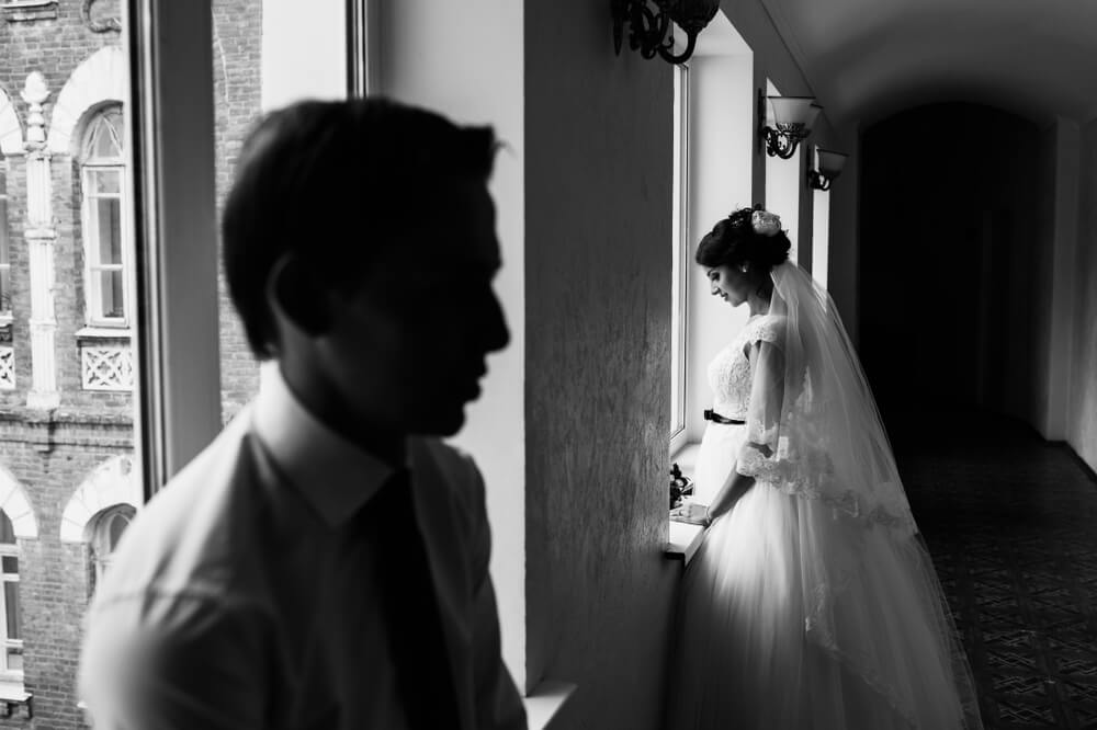 結婚式で新郎と新婦が目を合わさず距離を取っているモノクロの写真