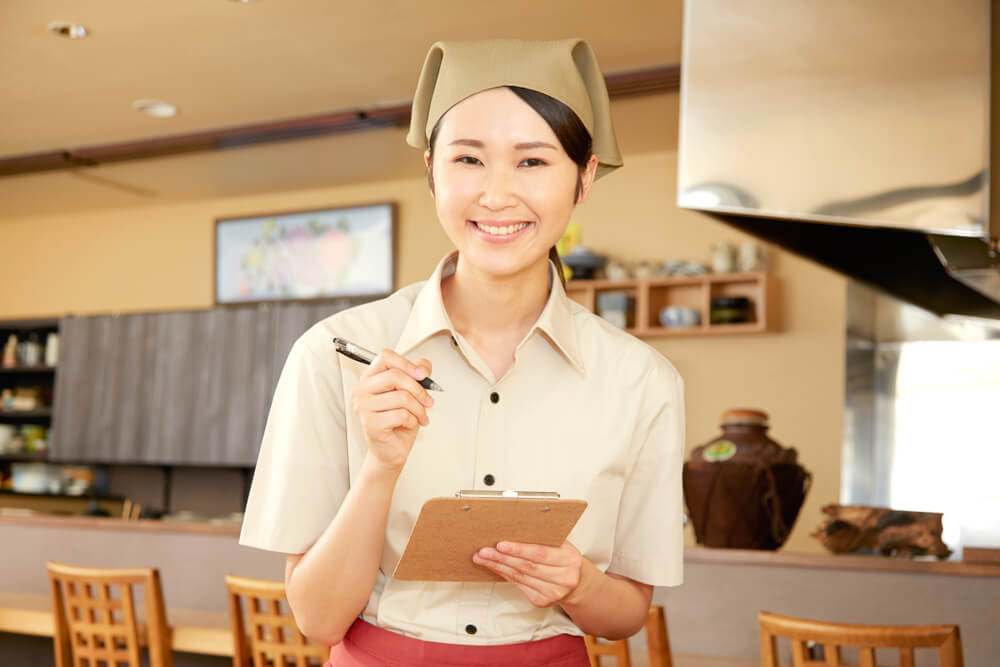 日本の居酒屋でアルバイトをする外国人留学生の女性