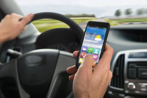スマートフォンを操作しながら運転している、交通違反の外国人