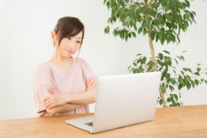 パソコンの前で首をかしげる女性