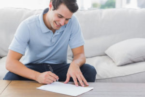 男性が楽しそうに婚姻にかかる書類を作成している