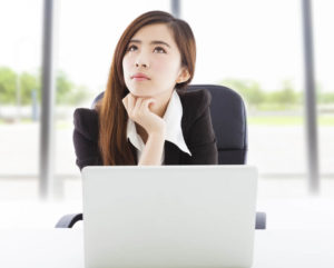 パソコンの前で困った表情を浮かべる中国人女性