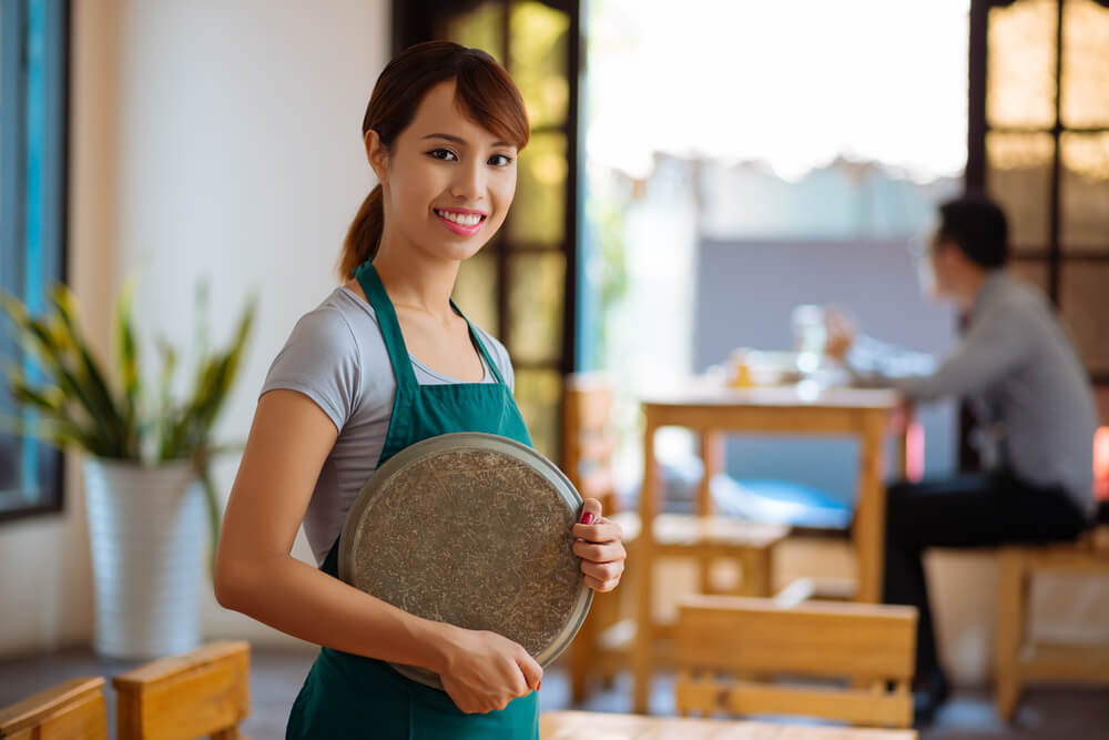 喫茶店でアルバイトをする東南アジア系の若い女性