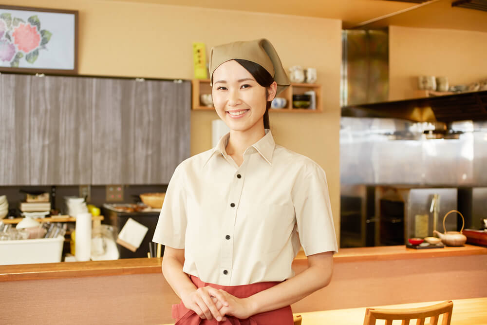 居酒屋でアルバイトをする若いアジア人女性