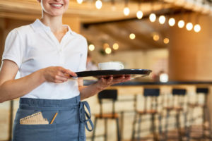 笑顔でコーヒーを運ぶ外国人女性