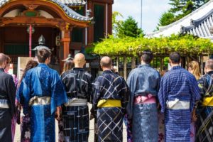国際結婚は減少していても、インバウンドは増加中!浴衣姿で神社の門の前に並ぶ外国人観光客たち