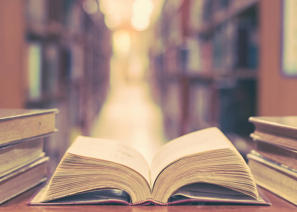 図書館の机の上に本が積んである